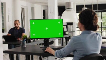 Analyst checks greenscreen desktop on pc, sitting in coworking space at agency office. Company worker examining computer monitor running blank copyspace with mockup screen. Handheld shot.