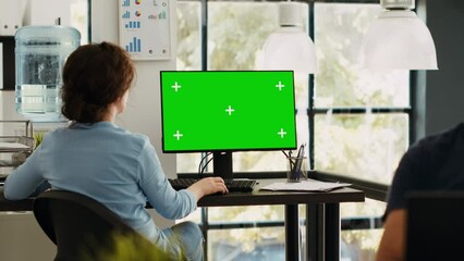 Poster - business manager working at monitor showing blank greenscreen template, sitting at office workstatio