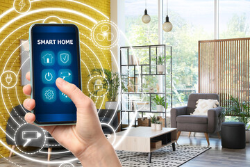 Canvas Print - Woman using smart home control system via application on mobile phone indoors, closeup. Scheme around device