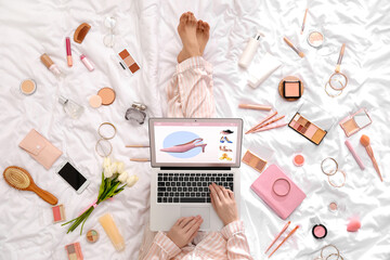 Poster - Woman with laptop, makeup products and accessories shopping online on white blanket