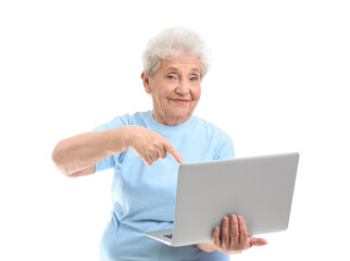 Poster - Senior woman pointing at laptop on white background