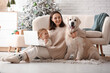 Young mother and her little daughter with cute Labrador dog at home on Christmas eve