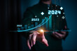 © teerawat - Businessman forecste analyze graph corporate future growth year 2024. New Goals with Plans and Visions for Next Year 2024, Opportunity, challenge and business strategy.