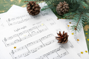 Wall Mural - Composition with music sheets, cones and fir branches on color background, closeup