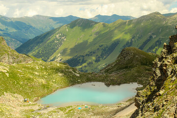 Wall Mural - Close up on the small Sophia lake with camps on bank. Arkhyz, Caucasus, Russia