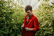 © La Famiglia - Young farmer in filed holding tablet in his hands and examining veggies
