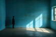A lonely man stands facing the wall in an empty room. Blue wall with shadows. Concept of human loneliness, social problems. Generative AI