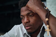 © Mediaphotos - African American upset young man with rosary beads thinking about his problems