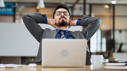 Tired businessman stretching in the office