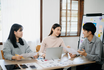 Wall Mural - Close up view of UI developer team brainstorming on their project with laptop, smartphone and digital tablet.