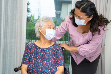 Wall Mural - Caregiver help Asian senior woman on wheelchair and wearing a face mask for protect safety infection Covid19 Coronavirus.