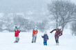 © somemeans - Children play snowballs outside during snowfall. Winter holidays. Games in winter outdoors.