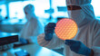 Lab technician holds semiconductor  silicone wafer in hands inside semiconductor fabrication plant