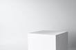 © Daydreamaster - blank mockup template empty square box platform pedestal cube to display isolated white clean background with grey shadow wall