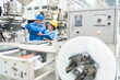 © Nutchapong Wuttisak - American male engineer and Asian female manager Inspecting work systems in plastic and steel industries Wearing a uniform and a hard hat, holding a list of notes, machinery is working around.