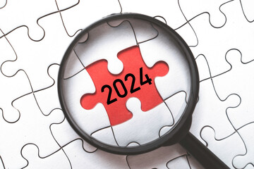 Wall Mural - 2024 year inside of magnifier glass and jigsaw puzzle for focusing in start new business of new year