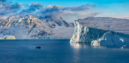 Adventure tourists in Scoresbysund in eastern Greenland in the late afternoon sunlight.