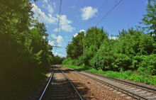 Summer green scenery with railroad tracks and blue sky