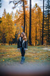 © MACO - Young girl walking through forest in autumn colors of yellow and orange. Meran, South Tirol, Italy