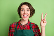 Photo of impressed nice short brown hair lady show v-sign wear red shirt isolated on pastel green color background