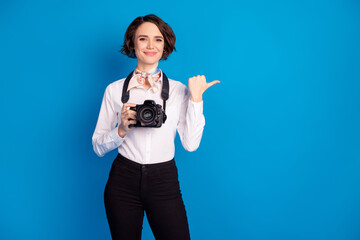 Canvas Print - Photo of charming positive lady hold camera direct thumb empty space isolated on blue color background