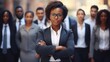 © Rakchanika - Young african American businesswoman standing in front of team of business people working in the office looking camera, executive manager female Afro hair wearing formal suit arm crossed confident