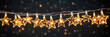 Christmas lighted string of stars near a background of bokeh lights.