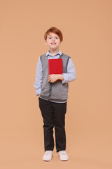 Sticker - Smiling schoolboy with book on beige background