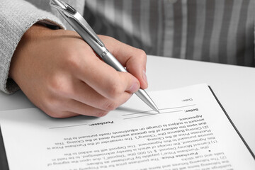 Canvas Print - Man signing document at white table, closeup