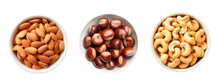 Top View Of Three Bowls Full Of Almonds, Hazelnuts And Cashews Over Isolated Transparent Background