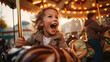 © MP Studio - A joyful young girl in a winter hat and scarf is smiling while riding on a carousel horse in the evening, illuminated by the ride's lights.