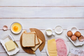 Prepared ingredients for making a hot croque madame sandwich on a white wooden background. Recipes for sandwiches, hot breakfasts.