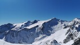 Fototapeta Góry - Aerial view of snowy rocky mountains on blue sky background