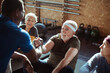 © Davor - Smiling senior man working out with assistance of personal trainer at gym