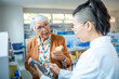 © Marko Geber - Senior woman customer consulting pharmacist about product in drugstore