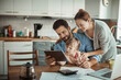 © Geber86 - Young family using tablet with documents on desk