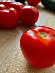 Vertical shot of fresh red tomatoes on a wooden table