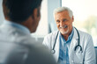 © MVProductions - Elderly male doctor with a joyful smile meeting his patient at the clinic