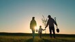 Happy family and child, team planting trees in spring. Silhouette of family with tree. Dad is farmer, mom is child planting trees. Green nature concept. Gardeners with shovel go to plant tree, sunset