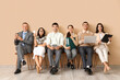 © Pixel-Shot - Business people sitting near beige wall
