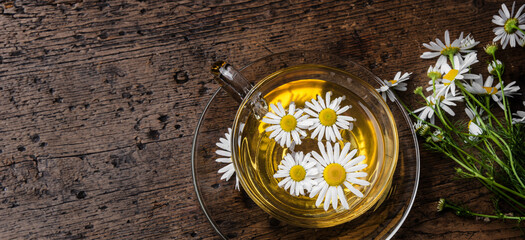 Poster - cup of camomile tea on an old wooden table - close up