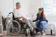 © Pixel-Shot - Senior man in wheelchair with caregiver at home