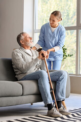 Wall Mural - Senior man with stick and nurse at home