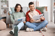© Pixel-Shot - Young couple with newspapers at home