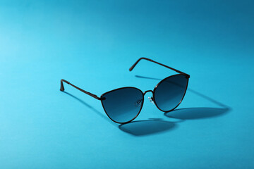 Sticker - Sunglasses on light blue background. Stylish accessory