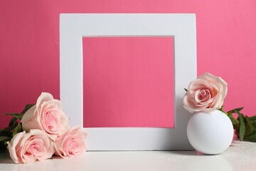 Canvas Print - Stylish presentation for product. Frame, beautiful roses and ball on light table against pink background, space for text