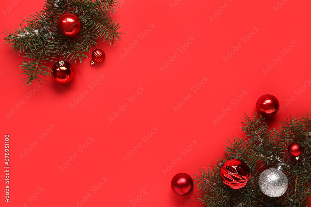 Fir twigs with Christmas balls on red background