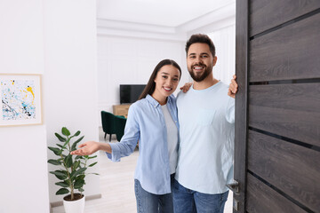 Wall Mural - Happy couple welcoming near door. Invitation to come indoors