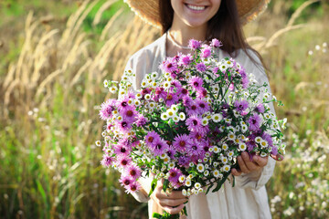 Wall Mural - Woman holding bouquet of beautiful wild flowers outdoors, closeup