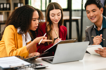 Diverse group of three professionals, two women and man, working together on design project around laptop. Product design team for industrial, working together, Asian man, African american people